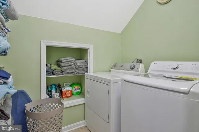 a bedroom with a bed a lamp on dresser and a chandelier