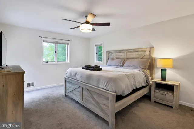 a bedroom with a large bed and a flat tv screen