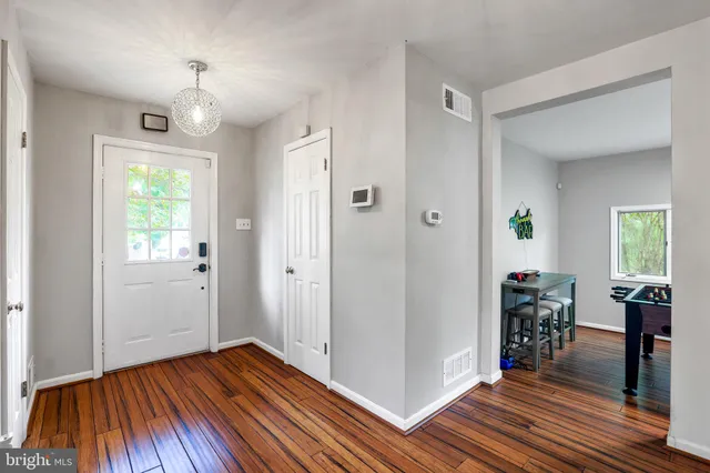 a view of a hallway with wooden floor and a living room