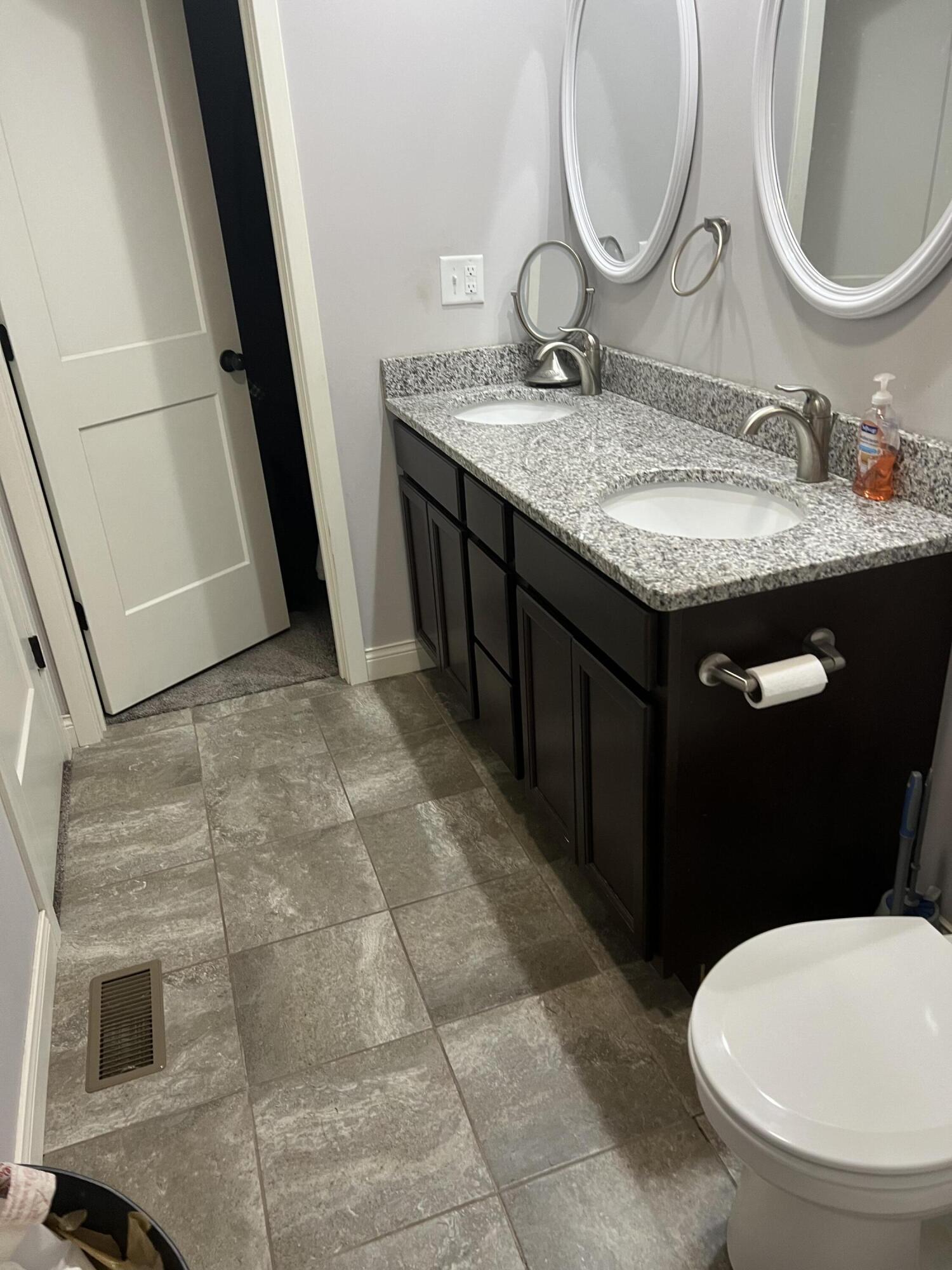 702 19th Street Southeast De Motte, IN 46310 - Photo 19 of 22 a bathroom with a granite countertop sink a mirror and a toilet