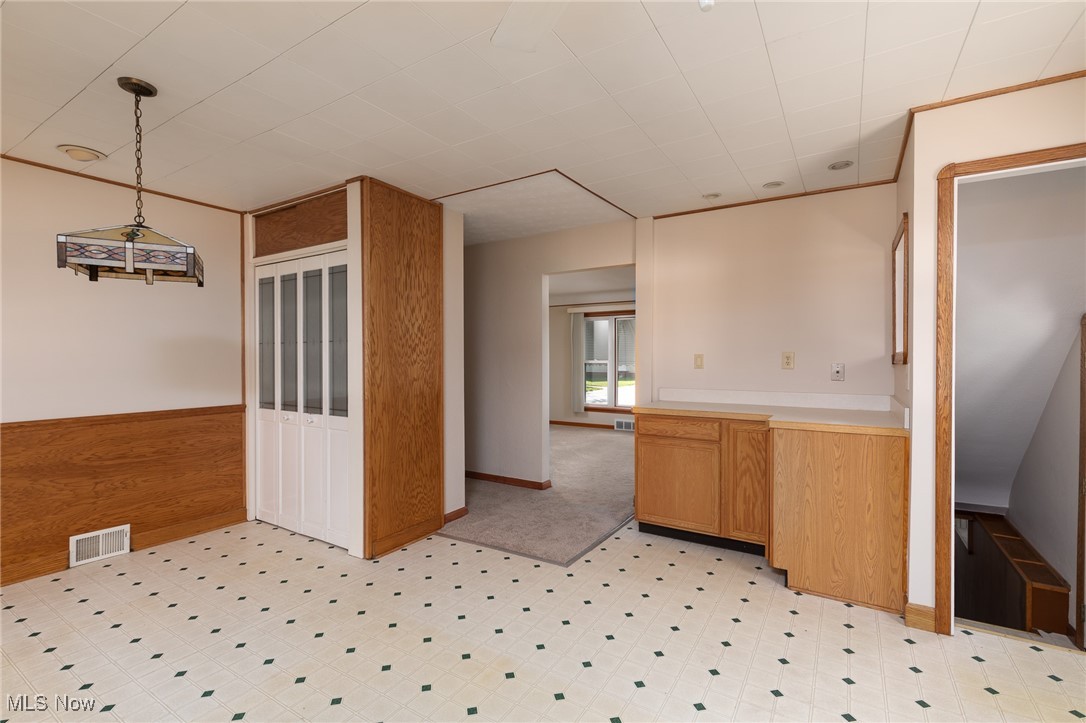 Kitchen featuring wood walls and decorative light fixtures