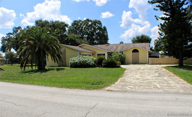 a front view of a house with a garden and yard
