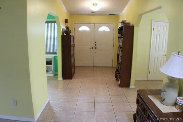 a view of a hallway with furniture and a bathroom