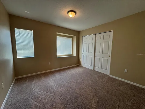 an empty room with windows and closet