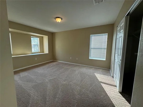 an empty room with windows and closet