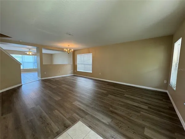 an empty room with a window and a ceiling fan