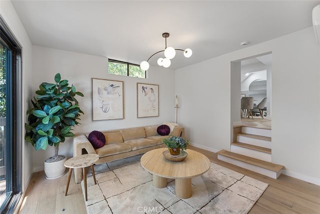 a living room with furniture potted plant and a mirror