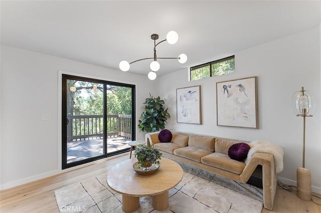 a living room with furniture a chandelier and a large window