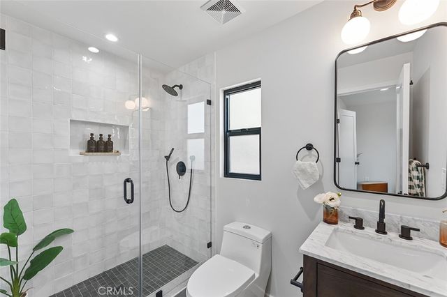 a bathroom with a granite countertop sink toilet and shower