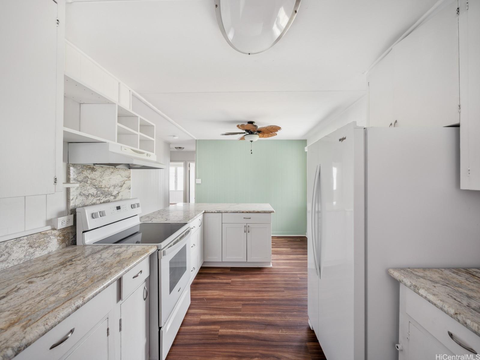 45-510 Pahia Road Kaneohe, HI 96744 - Photo 5 of 24 a kitchen with granite countertop a sink and dishwasher a stove top oven with wooden floor