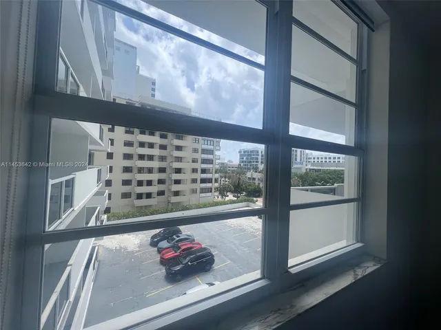a view of a tall building with a yard and plants