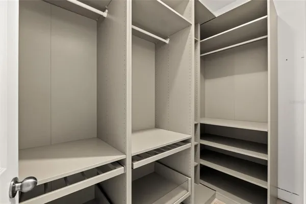 an empty room with closet and a ceiling fan
