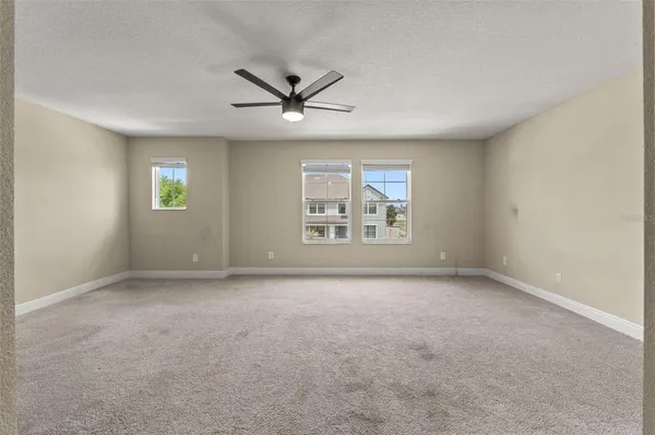 a view of an empty room with a window and wooden floor