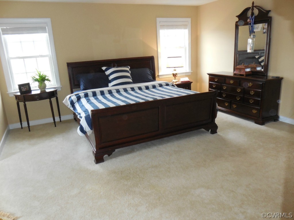 13213 Tipple Point Road Midlothian, VA 23114 - Photo 11 of 24 a spacious bedroom with a bed a table and dresser
