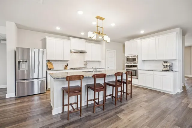 a kitchen with refrigerator a microwave and wooden floor