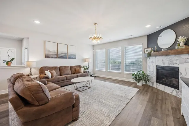 a living room with furniture a fireplace and a large window