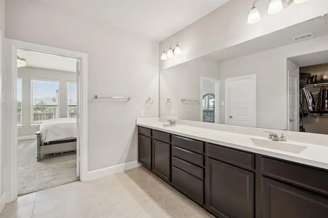 a en suite bathroom with double vanity and mirrors