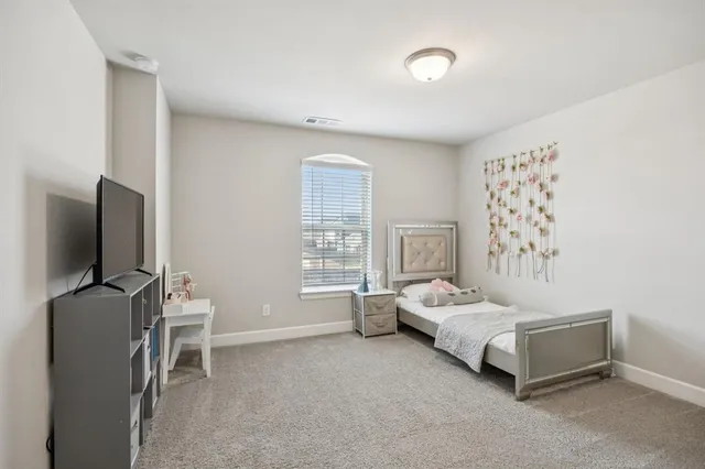 a bedroom with furniture and a flat screen tv