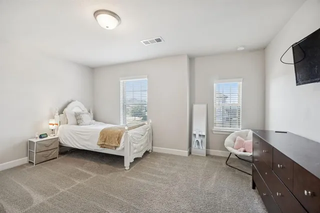 a spacious bedroom with a bed and a couch