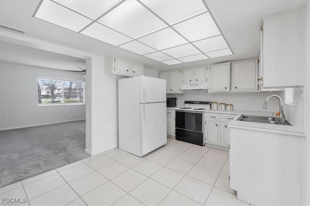 339 Joel Boulevard, Unit 121 Lehigh Acres, FL 33936 - Photo 11 of 40 a kitchen with a stove a sink and a refrigerator