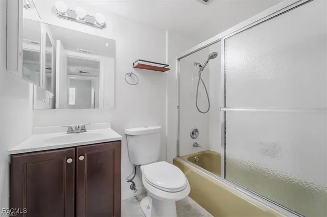 a bathroom with a granite countertop toilet sink and shower