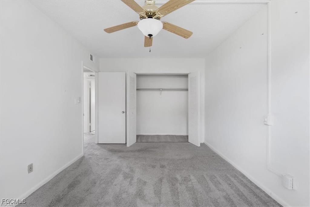 339 Joel Boulevard, Unit 121 Lehigh Acres, FL 33936 - Photo 16 of 40 an empty room with a ceiling fan and carpet
