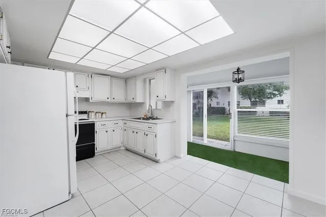 a kitchen with a sink a stove cabinets and a glass door