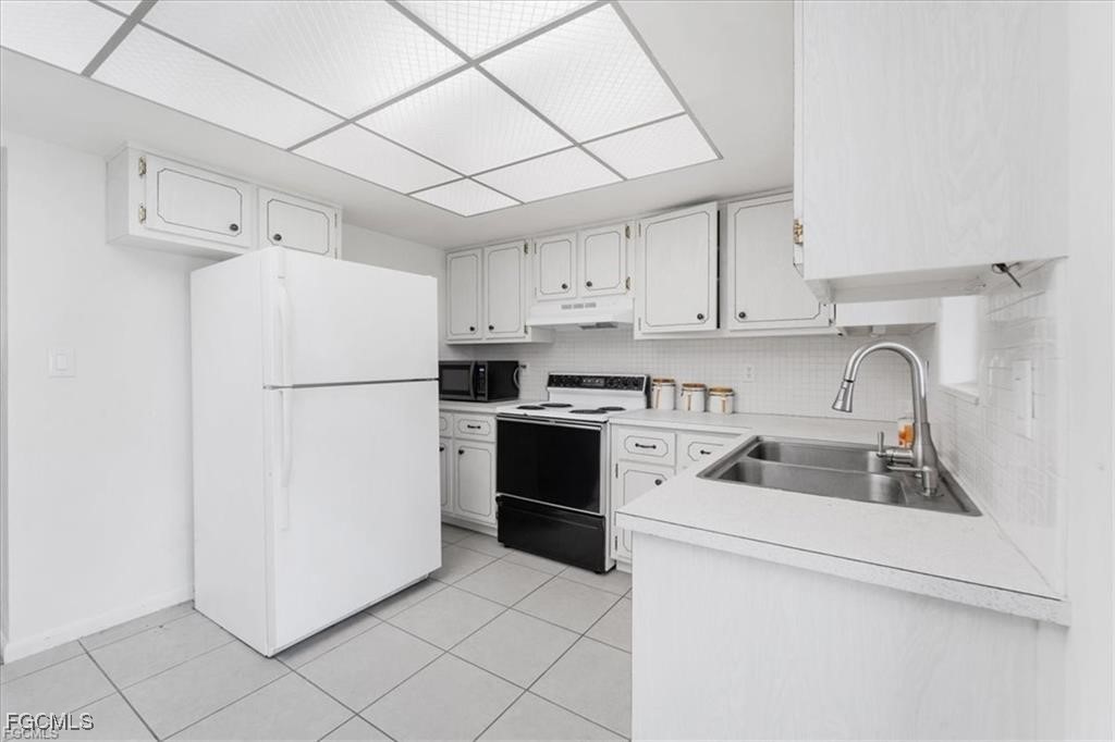 339 Joel Boulevard, Unit 121 Lehigh Acres, FL 33936 - Photo 21 of 40 a kitchen with a refrigerator sink and cabinets