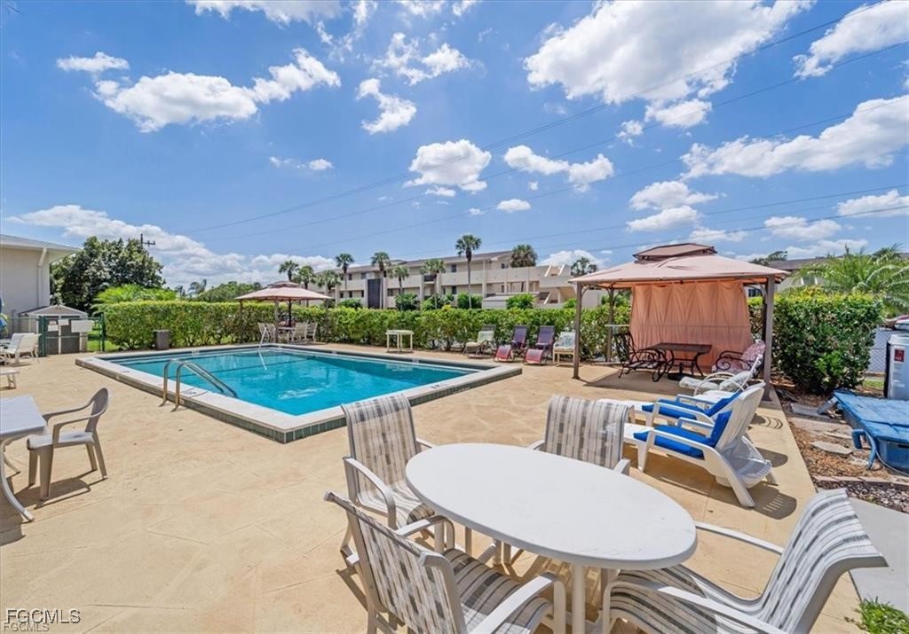 339 Joel Boulevard, Unit 121 Lehigh Acres, FL 33936 - Photo 34 of 40 a view of a swimming pool and lounge chairs