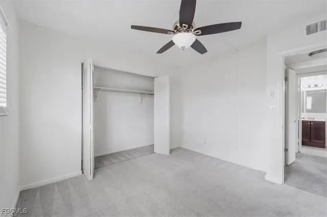 an empty room with closet and fan