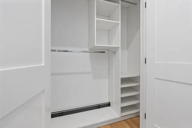 a view of walk in closet with empty racks