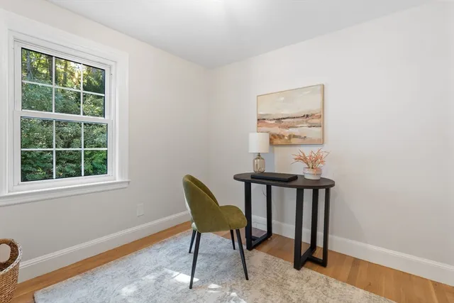 a view of a workspace with furniture and a window