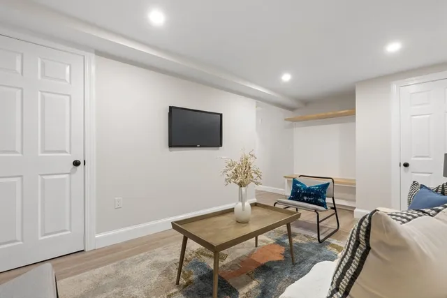 a living room with furniture a flat screen tv and kitchen view
