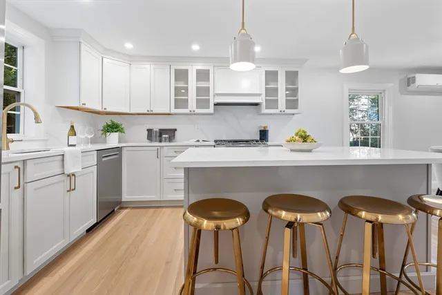 a kitchen with stainless steel appliances a table chairs refrigerator and sink