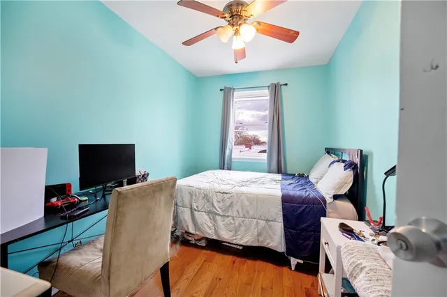 a bedroom with a bed and wooden floor