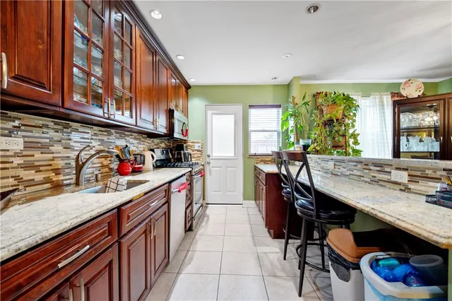 a kitchen with stainless steel appliances granite countertop a stove a sink dishwasher and cabinets with wooden floor