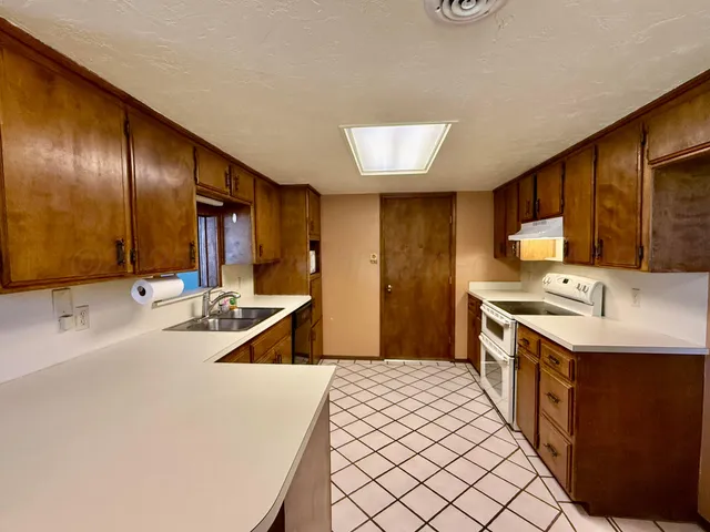 a kitchen with stainless steel appliances a sink stove and cabinets