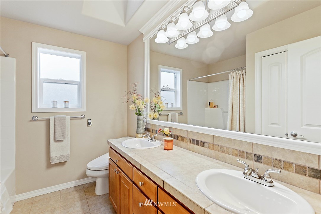 4124 215th Street Southeast Bothell, WA 98021 - Photo 16 of 30 a bathroom with a sink vanity granite toilet and a mirror