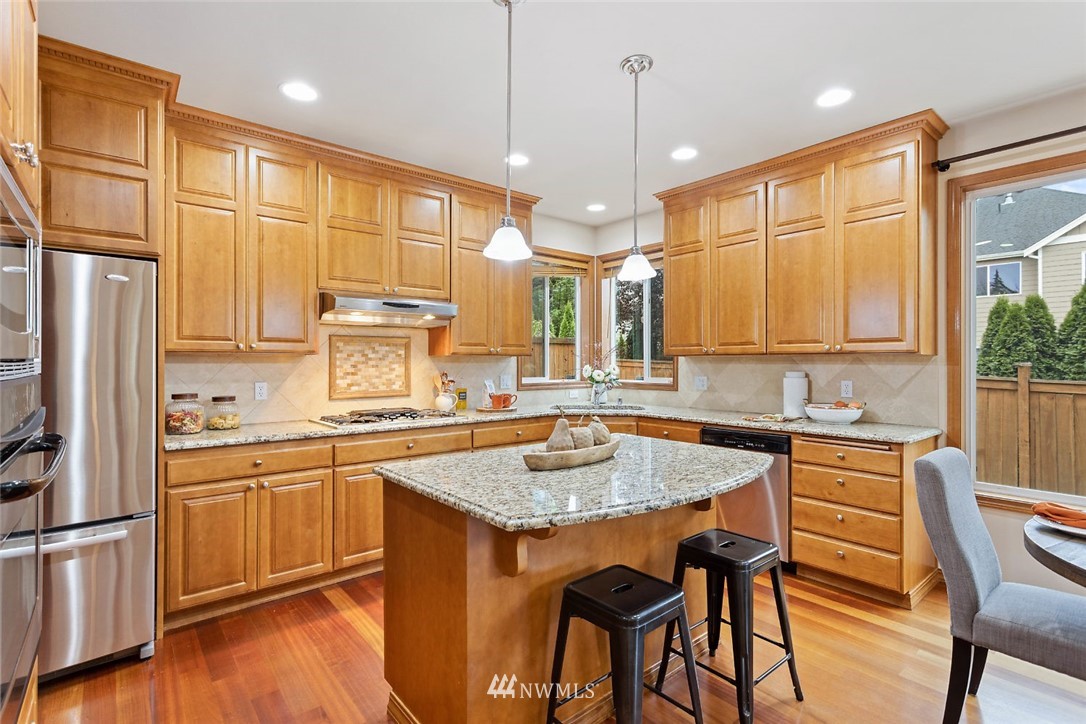 4124 215th Street Southeast Bothell, WA 98021 - Photo 5 of 30 a kitchen with stainless steel appliances granite countertop wooden floor a refrigerator a sink and a stove