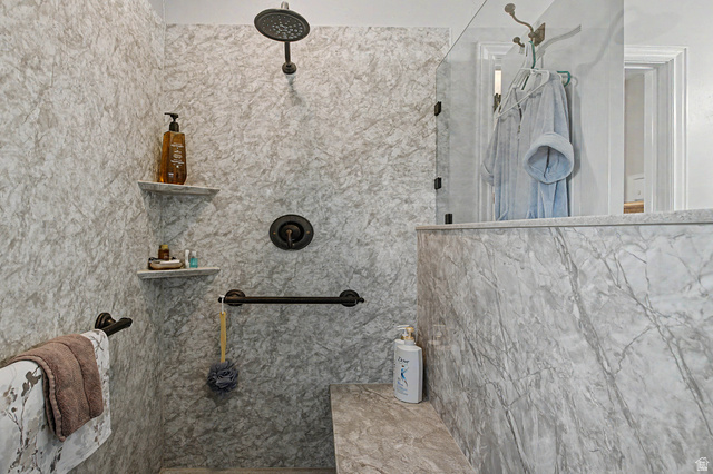 3034 Swiss Drive Santa Clara, UT 84765 - Photo 44 of 59 Walk-in shower with full-height stone-finish wall panels, a built-in bench, and a rain showerhead