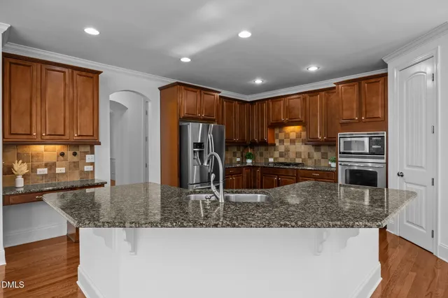 a kitchen with granite countertop stainless steel appliances and wooden cabinets