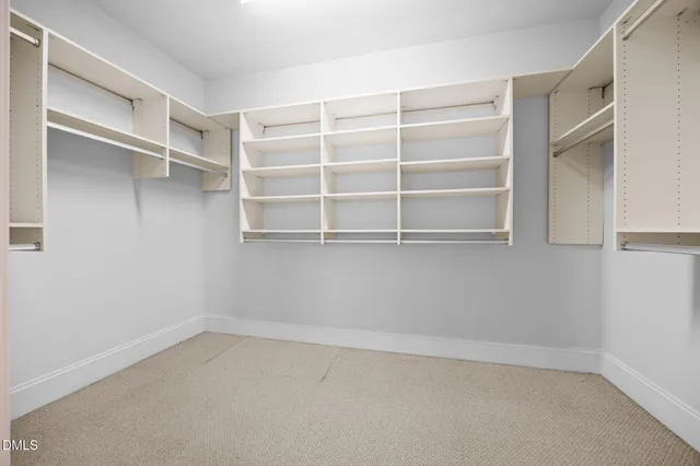 an empty room with windows and chandelier fan