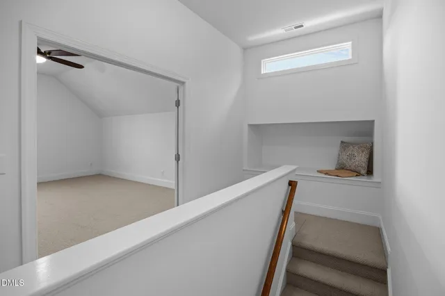 an empty room with a window and a fan