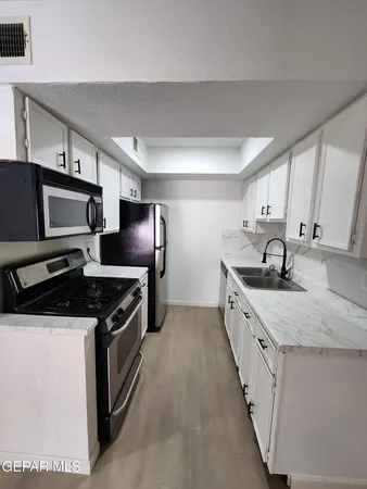 a kitchen with granite countertop a sink stove and cabinets