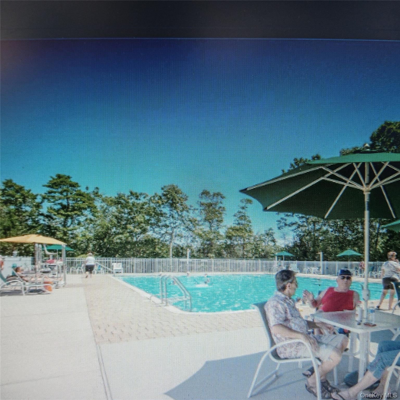 1661 Old Country Road, Unit 539 Riverhead, NY 11901 - Photo 26 of 26 an outdoor space with furniture and umbrella