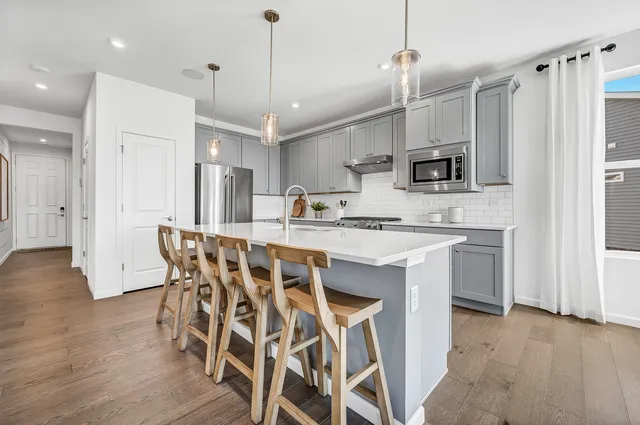 a kitchen with a table chairs refrigerator and microwave
