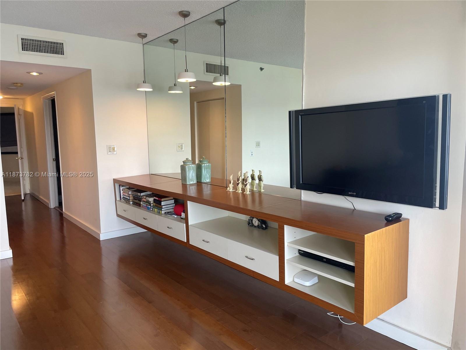 3000 Island Boulevard, Unit 2405 Aventura, FL 33160 - Photo 13 of 26 a living room with hard wood floor and flat screen tv