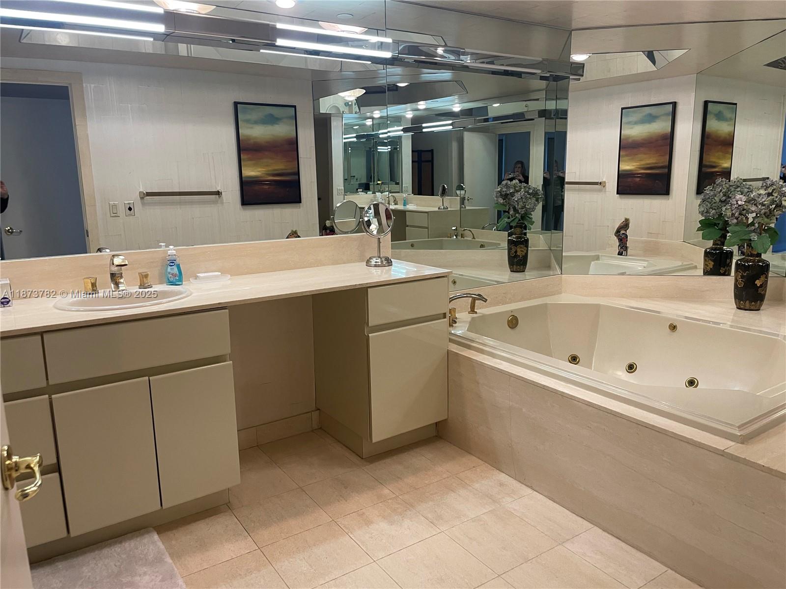 3000 Island Boulevard, Unit 2405 Aventura, FL 33160 - Photo 14 of 26 a spacious bathroom with a bathtub sink and mirror