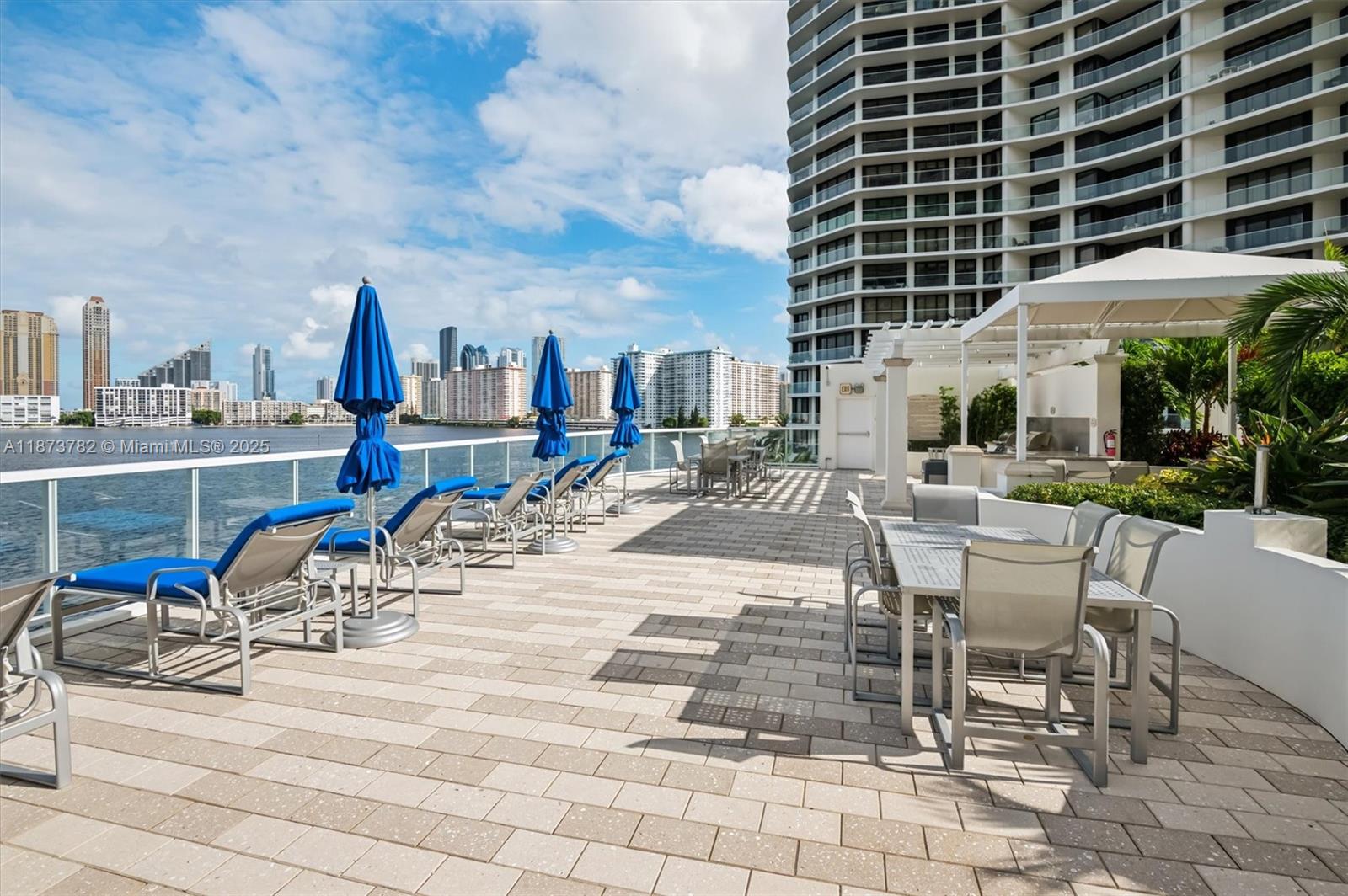 3000 Island Boulevard, Unit 2405 Aventura, FL 33160 - Photo 21 of 26 a view of a patio with a table and chairs and potted plants