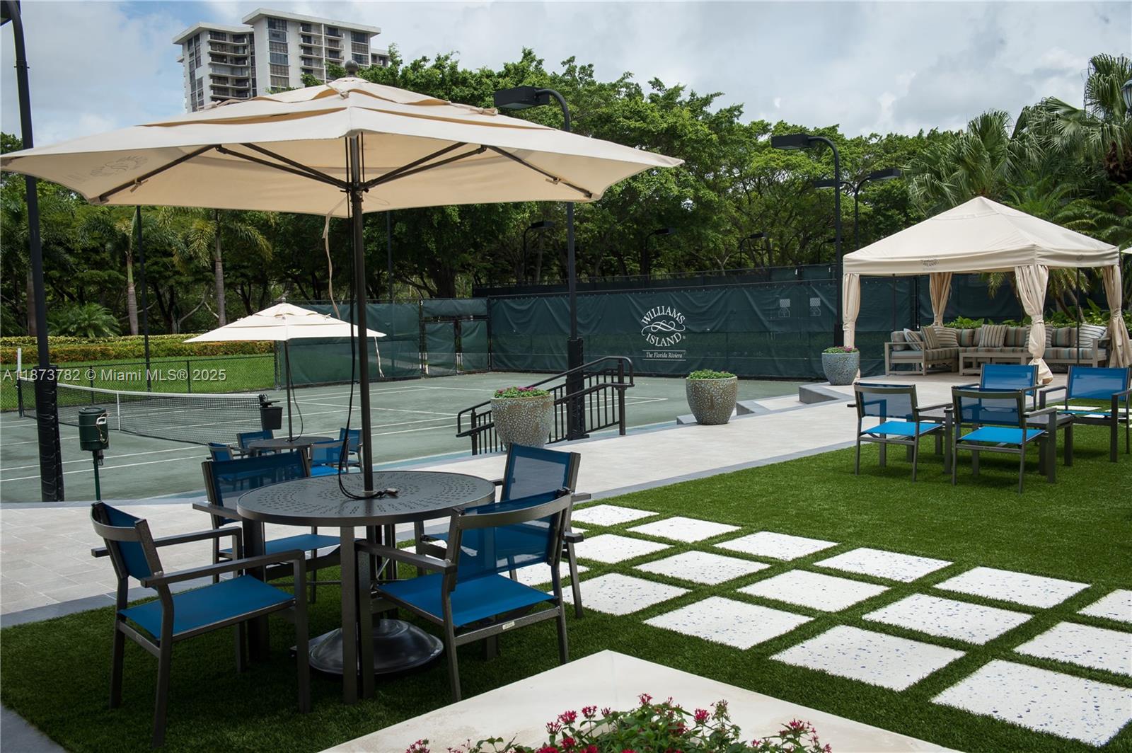 3000 Island Boulevard, Unit 2405 Aventura, FL 33160 - Photo 26 of 26 a view of a table and chairs under an umbrella in backyard
